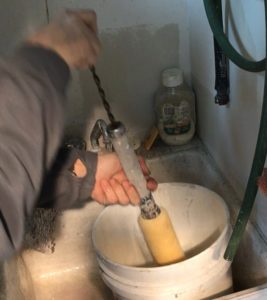 Man cleaning a paint roller with a spinner