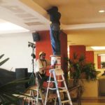 Man standing on the top of a step ladder.