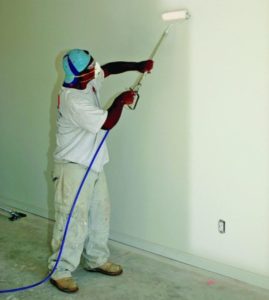 worker using a power paint roller